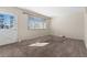 Bright living room with neutral carpet, large window, and a white door at 15303 E 10Th Ave, Aurora, CO 80011