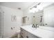 Well-lit bathroom with a modern vanity, mirror, and shower with white subway tile and decor at 9561 W Wesley Dr, Lakewood, CO 80227