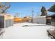 Snowy backyard with shed and fence at 1818 S Quitman St, Denver, CO 80219