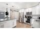 Modern kitchen featuring white cabinets, stainless steel appliances, and a farmhouse door at 1818 S Quitman St, Denver, CO 80219