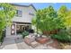 Backyard featuring modern seating, fire pit, green tree, and landscaped area with concrete patio at 3425 W Moncrieff Pl, Denver, CO 80211