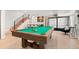 Basement area featuring a pool table, a staircase with metal railing, and stylish bar display at 3425 W Moncrieff Pl, Denver, CO 80211