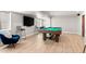 Spacious basement with a pool table, barstools, large TV, and ample room for entertaining at 3425 W Moncrieff Pl, Denver, CO 80211