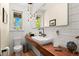 Stylish powder room featuring wood countertop, vessel sink, and unique light fixture at 3425 W Moncrieff Pl, Denver, CO 80211