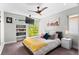 Sun-filled bedroom featuring ceiling fan, large window and custom built-in shelving at 3425 W Moncrieff Pl, Denver, CO 80211