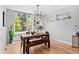 Bright dining room features a large window, wood table and bench, hardwood floors and modern lighting at 3425 W Moncrieff Pl, Denver, CO 80211