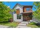 Modern two-story home featuring a red front door and a mix of white siding and stained wood accents at 3425 W Moncrieff Pl, Denver, CO 80211
