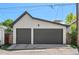 View of the detached two car garage with gray doors and a peak roof at 3425 W Moncrieff Pl, Denver, CO 80211