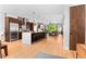 Open kitchen with stainless steel appliances, hardwood floors and a large center island with bar stool seating at 3425 W Moncrieff Pl, Denver, CO 80211