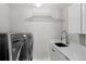 Well-equipped laundry room features modern washer, dryer, white cabinets, sleek countertops, and ample storage at 3425 W Moncrieff Pl, Denver, CO 80211