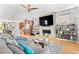 Open living room with hardwood floors, fireplace, built-in bookshelves, and view to open kitchen at 3425 W Moncrieff Pl, Denver, CO 80211