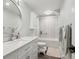 Bathroom featuring a round mirror, white cabinets, and a shower and tub combination at 2262 Ammons St, Lakewood, CO 80214