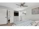 Bright bedroom with a ceiling fan, built-in storage with a TV, and a modern striped comforter at 2262 Ammons St, Lakewood, CO 80214