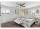 Bright bedroom with carpet flooring, bench, soft bedding, ceiling fan, and plenty of natural light from two windows at 2262 Ammons St, Lakewood, CO 80214