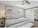 Bright bedroom with carpet flooring, bench, soft bedding, ceiling fan, sliding closet doors, and nightstands at 2262 Ammons St, Lakewood, CO 80214