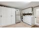 Functional laundry room with washer, dryer, sink, and abundant storage at 2262 Ammons St, Lakewood, CO 80214