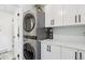 Laundry room with stackable washer and dryer, and white cabinets at 2262 Ammons St, Lakewood, CO 80214