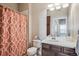 Cozy bathroom featuring a shower with a patterned curtain, a vanity with a sink, and a toilet at 10111 Inverness Main St # 230, Englewood, CO 80112