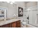 Elegant bathroom with granite countertops, wooden cabinetry, and a glass-enclosed shower, combining style and functionality at 10111 Inverness Main St # 230, Englewood, CO 80112