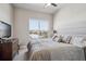 Comfortable bedroom with a large window offering city views, complemented by neutral tones and plush bedding at 10111 Inverness Main St # 230, Englewood, CO 80112