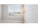 Bright bedroom featuring a window with blinds, a floor lamp, and neutral-toned walls, creating a serene atmosphere at 10111 Inverness Main St # 230, Englewood, CO 80112