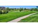 Expansive view of the golf course with a concrete path cutting through the manicured lawns and green spaces on a sunny day at 10111 Inverness Main St # 230, Englewood, CO 80112