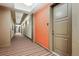 Well-lit hallway with striped carpeting leading to apartment doors, offering a clean and inviting entrance at 10111 Inverness Main St # 230, Englewood, CO 80112