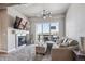 Bright living room featuring a modern fireplace, comfortable seating, and a large window with outdoor views and balcony access at 10111 Inverness Main St # 230, Englewood, CO 80112