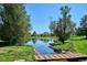 A tranquil pond view with trees, lush greenery, and a wooden bridge in the foreground on a scenic golf course at 10111 Inverness Main St # 230, Englewood, CO 80112