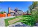 Expansive backyard with a wooden deck, lush grass, gravel area, and privacy fence, perfect for outdoor living at 6527 S Yarrow Way, Littleton, CO 80123