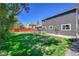 Picturesque backyard featuring a wood deck, lush lawn, privacy fence, and mature trees at 6527 S Yarrow Way, Littleton, CO 80123