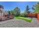 Landscaped backyard with a wood deck, gravel area, grass lawn, and wood fence for privacy at 6527 S Yarrow Way, Littleton, CO 80123