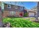 Beautifully maintained two-story house featuring a vibrant green lawn, mature tree, and inviting red front doors at 6527 S Yarrow Way, Littleton, CO 80123