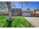 Charming two-story home with a well-manicured lawn, brick accents and a two car garage on a sunny day at 6527 S Yarrow Way, Littleton, CO 80123