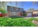 Beautifully maintained two-story house featuring a vibrant green lawn, mature tree, and inviting red front doors at 6527 S Yarrow Way, Littleton, CO 80123