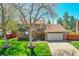 Charming two-story home with a well-manicured lawn, mature trees, brick accents, and an attached garage at 6527 S Yarrow Way, Littleton, CO 80123