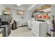 Well-lit laundry room with patterned floors, shelving, utility sink, and modern washer and dryer units at 6527 S Yarrow Way, Littleton, CO 80123