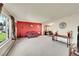 Spacious living room featuring a large window, red accent wall, and comfortable seating arrangement at 6527 S Yarrow Way, Littleton, CO 80123