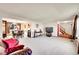 Open-concept living space with a view of the dining area, stairs, and large TV screen at 6527 S Yarrow Way, Littleton, CO 80123
