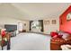 Bright living room with a large window, plush carpet, and a cozy leather sofa at 6527 S Yarrow Way, Littleton, CO 80123
