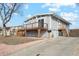 Grey two-story home with wood deck, gravel landscaping, and concrete driveway on a partly cloudy day at 201 Greenwood Blvd, Denver, CO 80221