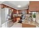 Kitchen area featuring stainless steel appliances, tile backsplash, and updated wood cabinets at 201 Greenwood Blvd, Denver, CO 80221