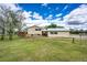 Expansive backyard featuring lush green grass and mature trees at 73 N Dutch Valley Rd, Bennett, CO 80102