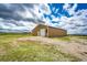 Large tan barn with rolling door and ample land, perfect for storage at 73 N Dutch Valley Rd, Bennett, CO 80102