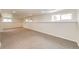 Finished basement with carpeted floors, several windows and white walls at 73 N Dutch Valley Rd, Bennett, CO 80102