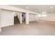 Large basement with carpet floors, white support beams and stairs at 73 N Dutch Valley Rd, Bennett, CO 80102