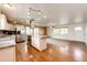 Open concept kitchen, living room featuring hardwood floors, an island and stainless appliances at 73 N Dutch Valley Rd, Bennett, CO 80102