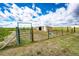 Expansive plot of land with fencing and a storage shed under a cloudy sky at 73 N Dutch Valley Rd, Bennett, CO 80102