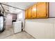 Unfinished basement laundry area with washer, dryer and utility sink at 73 N Dutch Valley Rd, Bennett, CO 80102