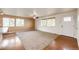 Bright living room with lots of windows, and hardwood floors is open to the kitchen at 73 N Dutch Valley Rd, Bennett, CO 80102